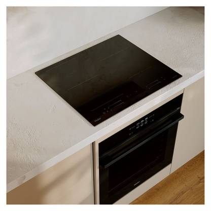 Angled image of the Haier induction cooktop and Haier single oven in a modern kitchen with a white benchtop and wooden cabinetry.