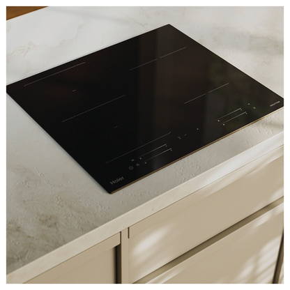 Angled image of Haier induction cooktop installed on a white benchtop.