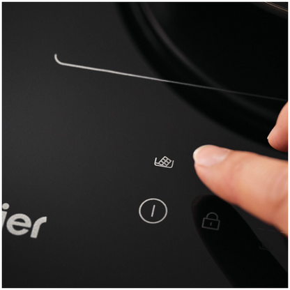 Person using the touch controls on the Haier induction cooktop.