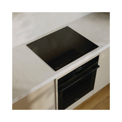 Angled image of a Haier induction cooktop and a Haier single oven installed below it.