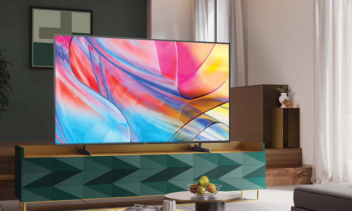 Hisense Ultra HD TV with a vibrantly coloured abstract image inlay sitting on a green cabinet in a lounge