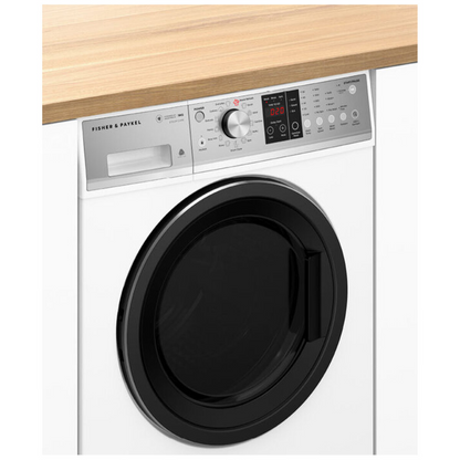 Angle view of the Fisher & Paykel 9kg Front Load washing machine in a white finish, in modern laundry set up, with white cabinetry beside it and a wooden benchtop above it.