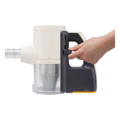 Hand holding a gray and white handheld LG vacuum cleaner on a white background