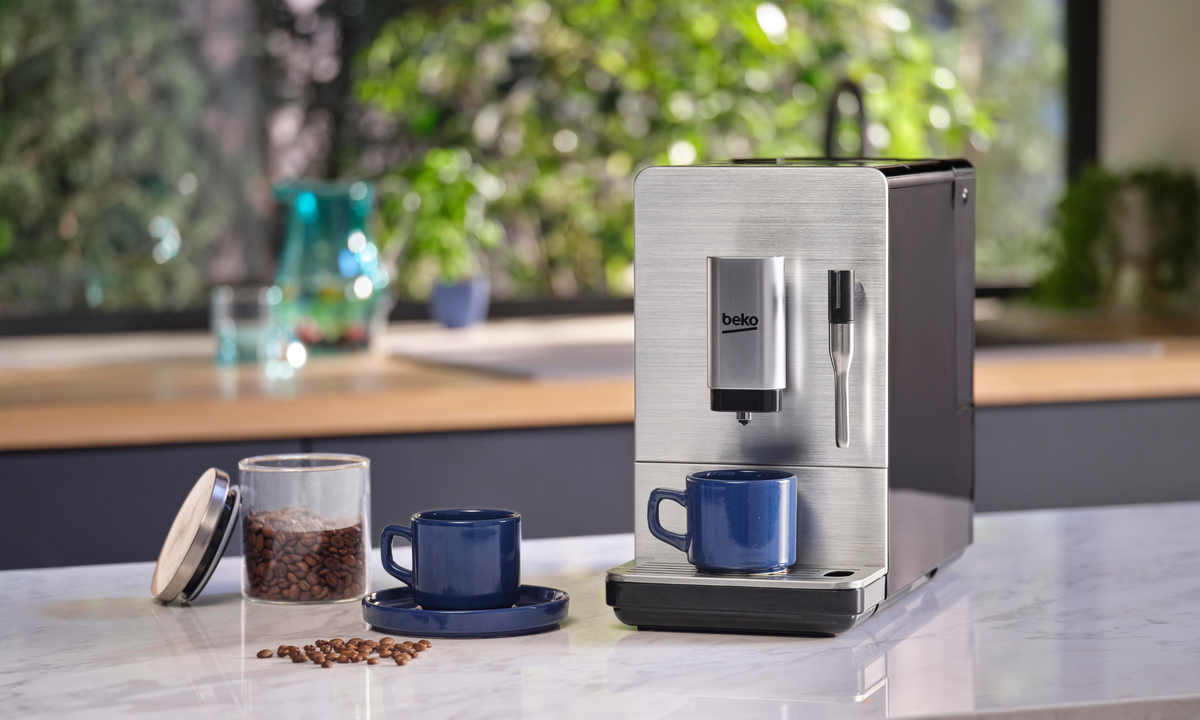 A Beko Coffee Machine sitting on a counter with a lush landscape of greenery visible from the window behind