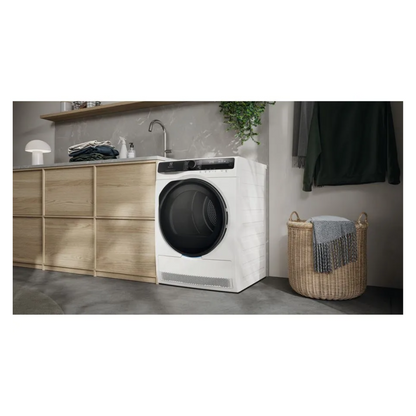 White Electrolux dryer in a laundry room with wooden cabinets and a basket.
