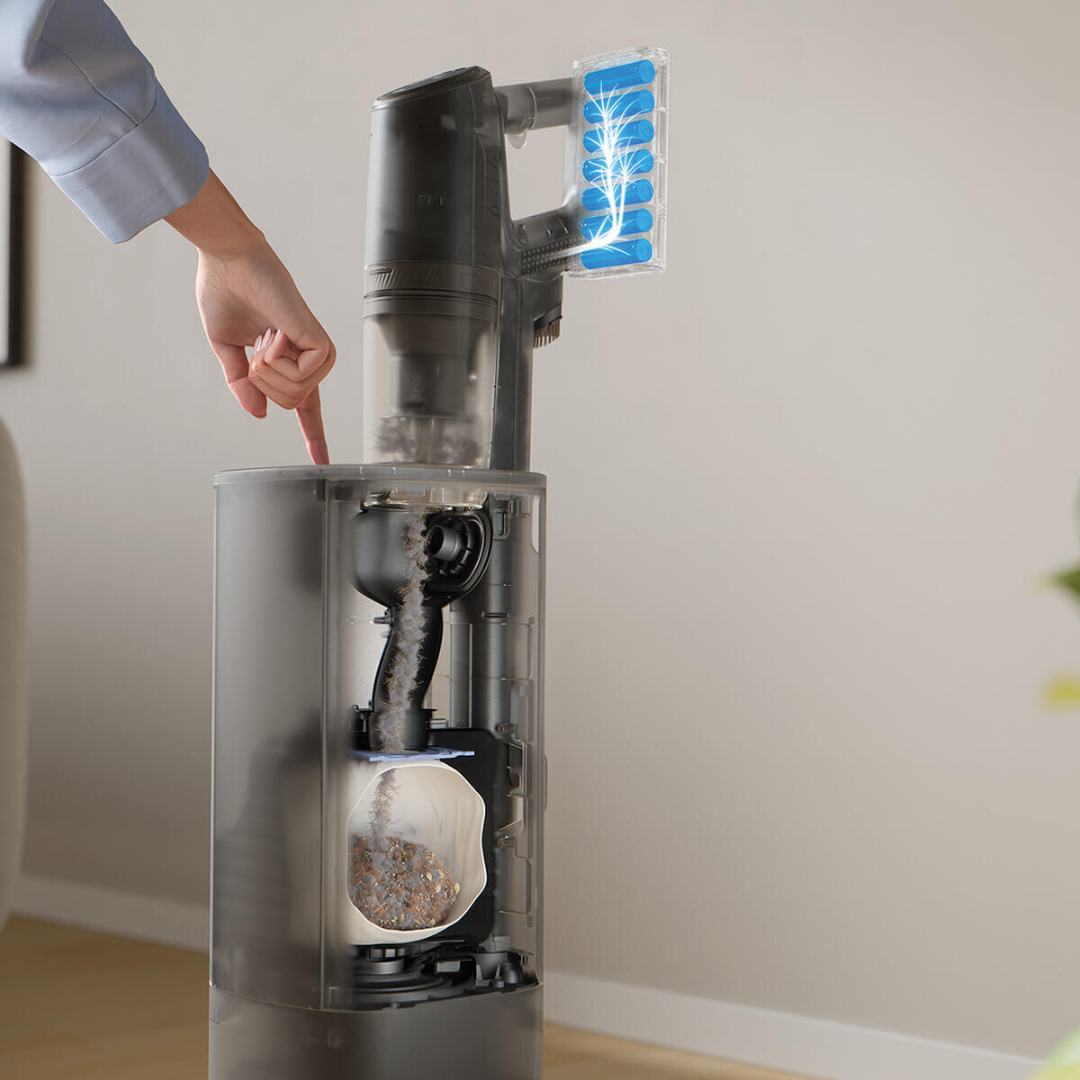 Electrolux 800 series cordless stick vacuum with clean station, illustrating dust being automatically emptied into a bagged container, showing hygienic hands free dirt disposal. 