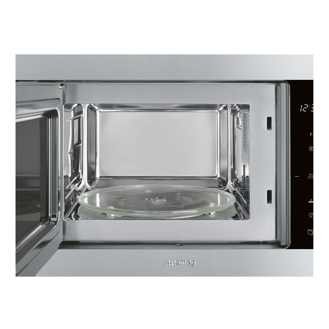 Smeg Stainless steel built-in microwave oven with open door on a white background
