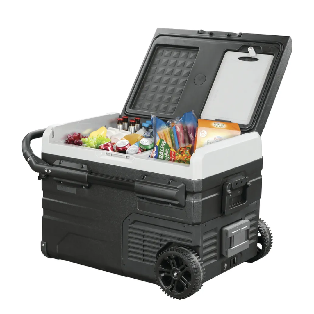 Angled view of the Brass Monkey portable fridge freezer open with drinks, fruits, and frozen good inside, featuring rugged wheels and telescopic handles, perfect for camping and outdoor use.