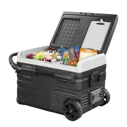 Angled view of the Brass Monkey portable fridge freezer open with drinks, fruits, and frozen good inside, featuring rugged wheels and telescopic handles, perfect for camping and outdoor use.