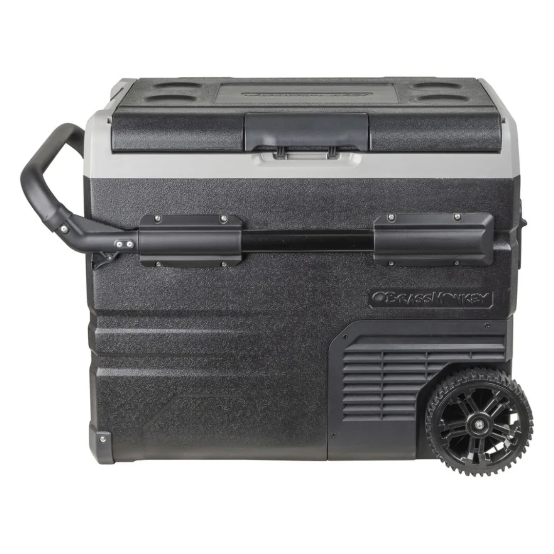 Brass Monkey portable fridge/freezer with lid closed, heavy-duty wheels and extendable handle, ideal for camping, travel and outdoor use.