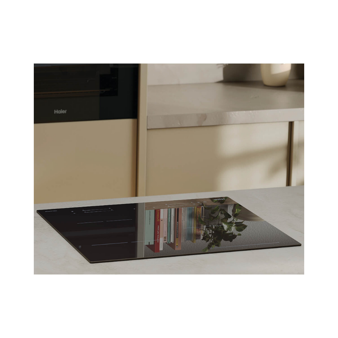 Lifestyle image of the Haier induction cooktop installed on a marble benchtop with a Haier oven in the background. 