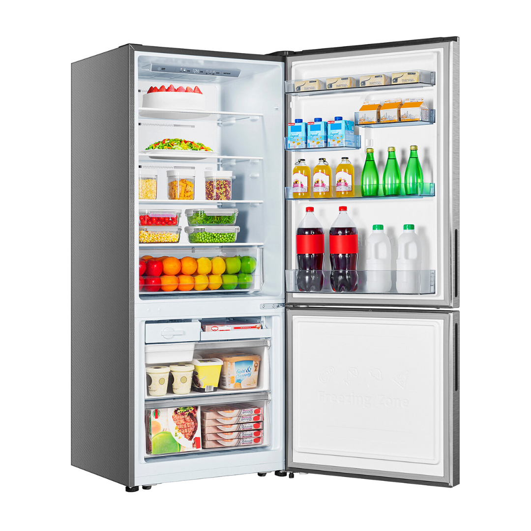 Angle view of the Hisense 417L bottom mount fridge in a silver finish with the doors open, showing organised shelves, fresh produce draws, door bin storage and freezer compartments. 