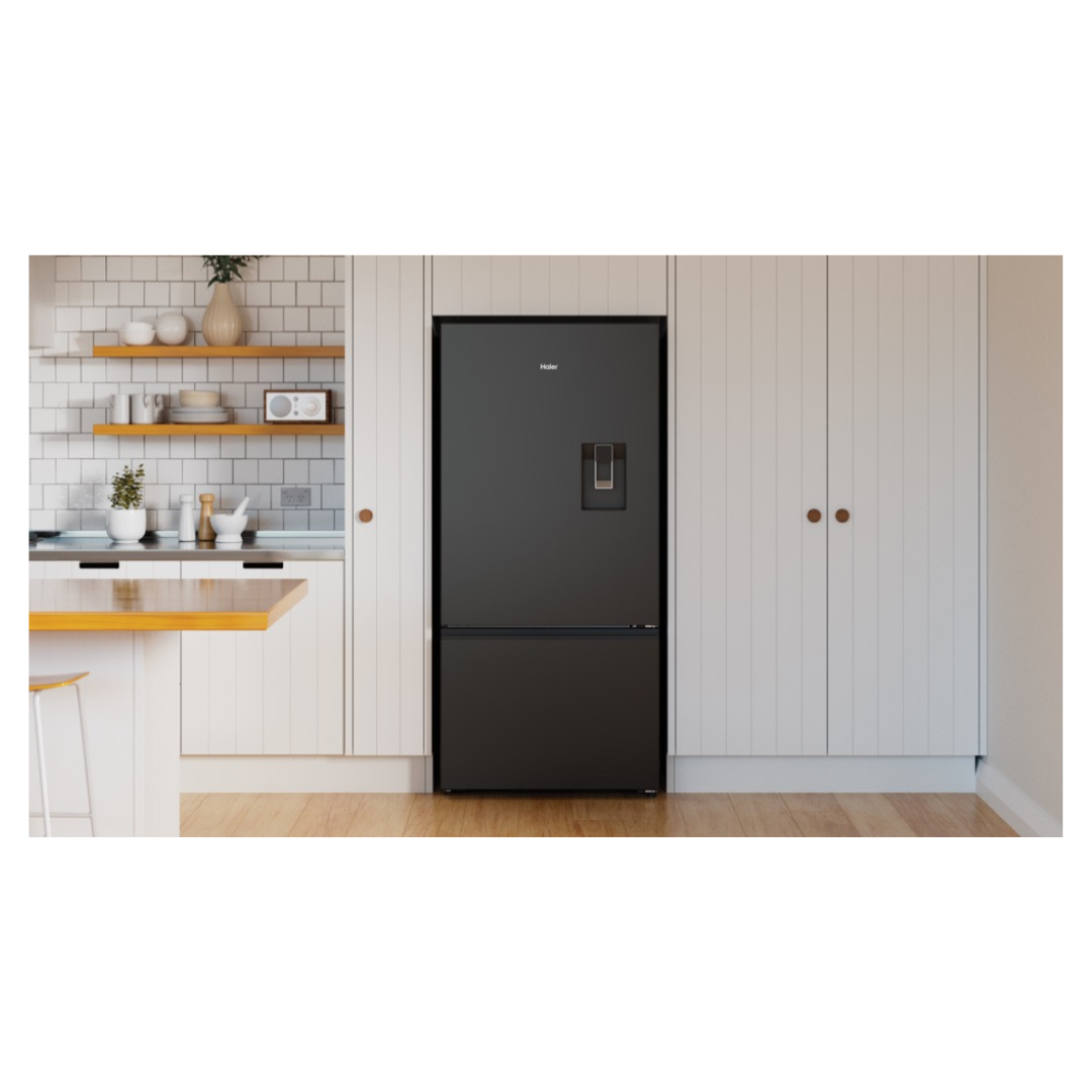 Haier Bottom Mount Fridge with a water dispenser in Black in a modern kitchen setting