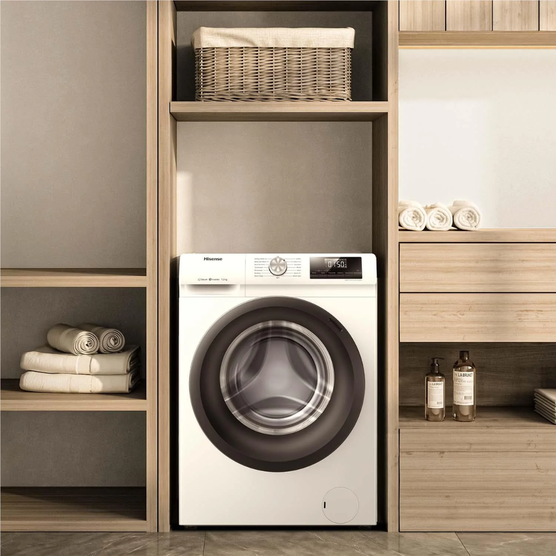Front view of the Hisense 7.5kg front load washing machine in a white finish, in a modern laundry room, with wooden shelving besides it, with towels and detergents nearby. 