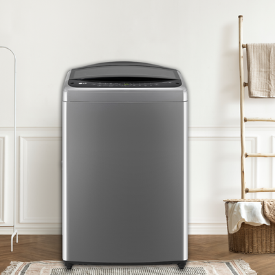 A sleek silver top-loading washing machine in a bright room with white walls, accompanied by a wicker basket and under a wooden ladder. Promoting laundry deals at Bi-Rite Home Appliances 