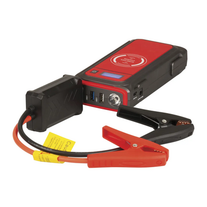 Portable jump starter with USB ports, LED torch and smart clamps for vehicle battery charging, featuring red and black alligator clips and wireless charging pad. 