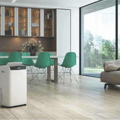 Modern dining area with green chairs and a large window view with the Olimpia Splendid dehumidifier on the left 