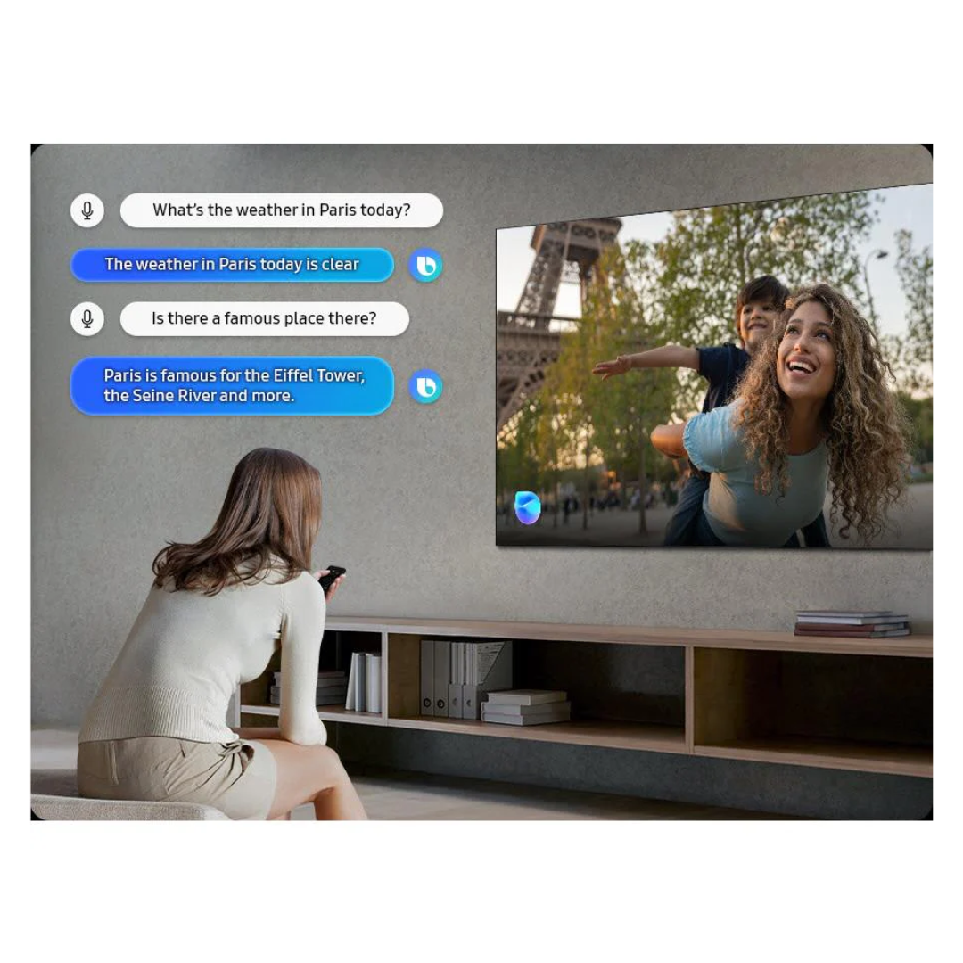A women using voice commands with a Samsung Smart tv shwoing bixby responses on screen. The TV is displaying a scene near the Eiffel Tower. 
