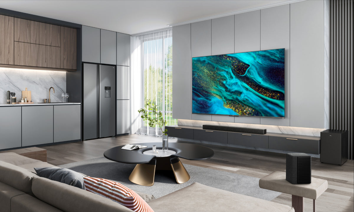 An open plan living area featuring a large TV with a green abstract inlay and beneath it on the cabinet is a TCL Soundbar