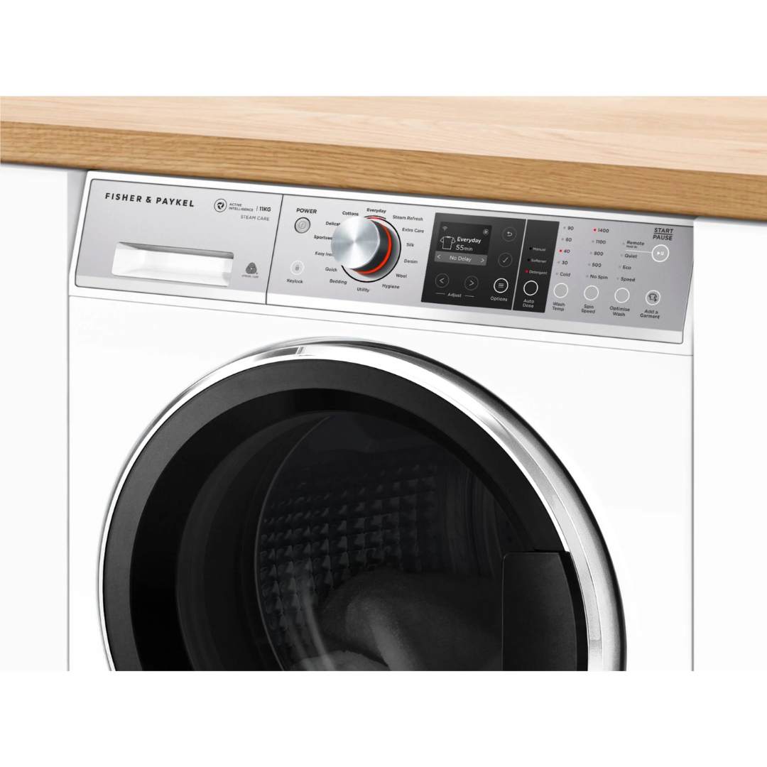 Angle close up view of the Fisher & Paykel 11kg front load washing machine, showing the top panel, with the controls, digital display, control knob and detergent dispenser.