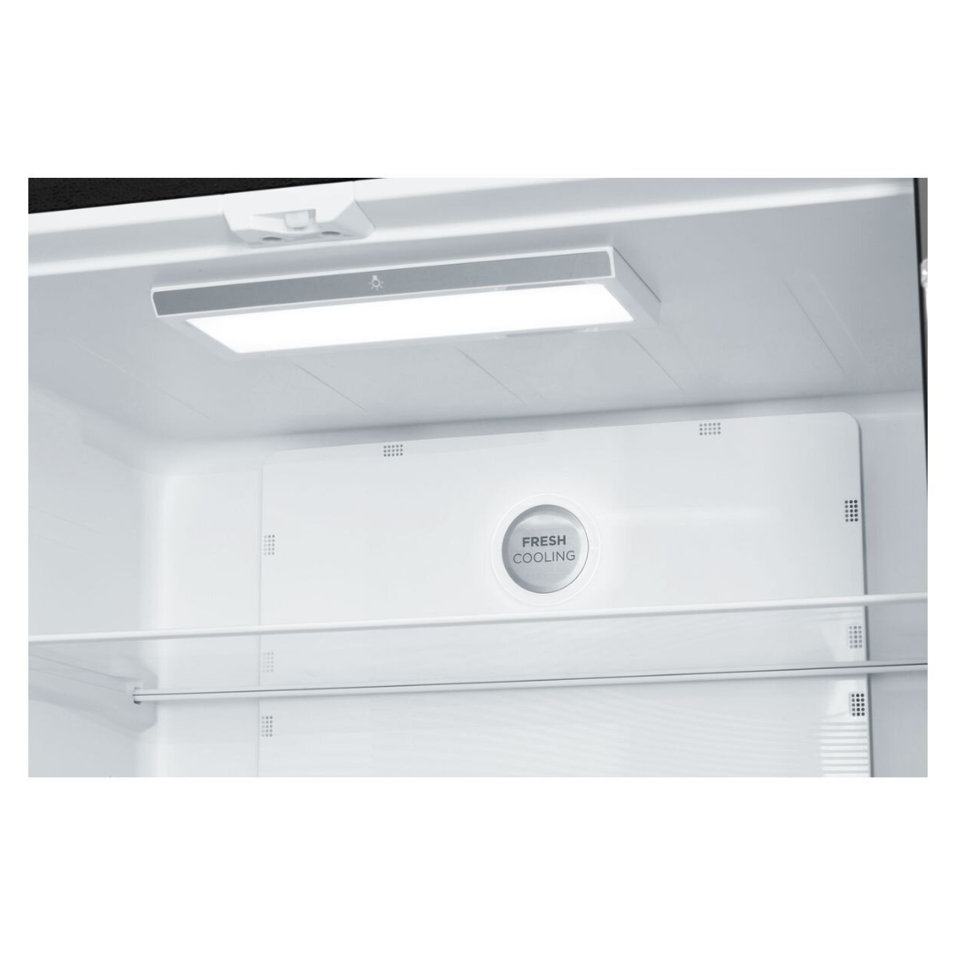 A close up view of the top interior section of the Westinghouse 496L French Door Fridge. A bright LED light illuminating the section and a circular "fresh cooling" vent on the back panel. A glass shelf is visible beneath the vent.  