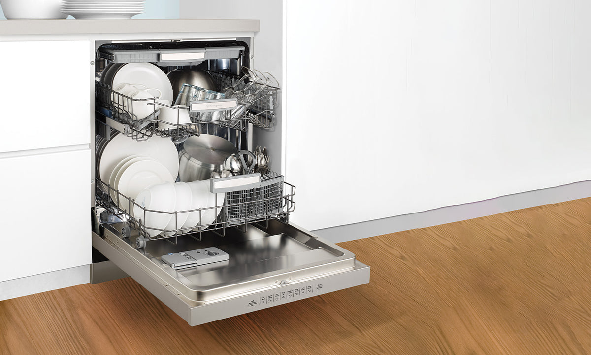 Westinghouse dishwasher featured in a kitchen with only white walls visible and wooden flooring